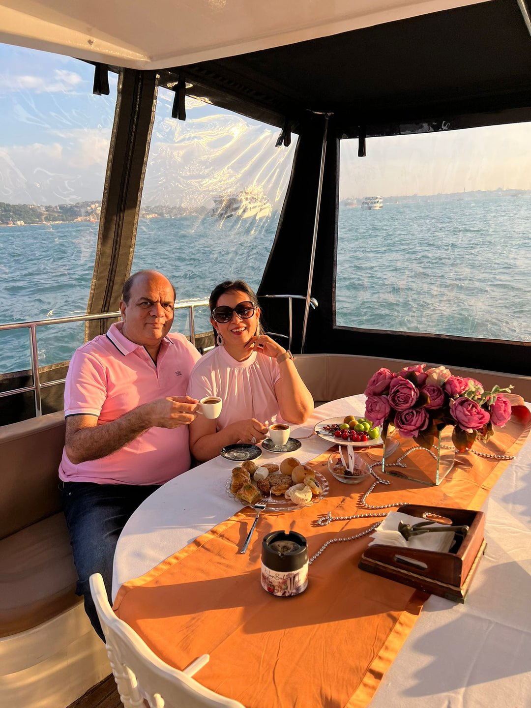 Tourists on a private yacht tour approaching Istanbul's Ortaköy Mosque.